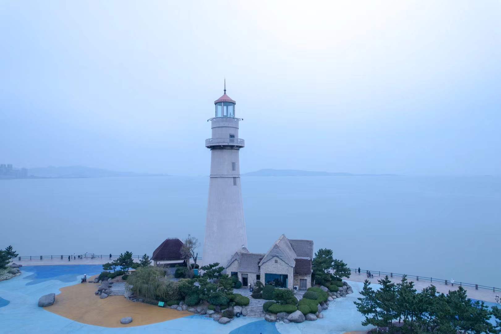 A small lighthouse beside a blue-grey sea
