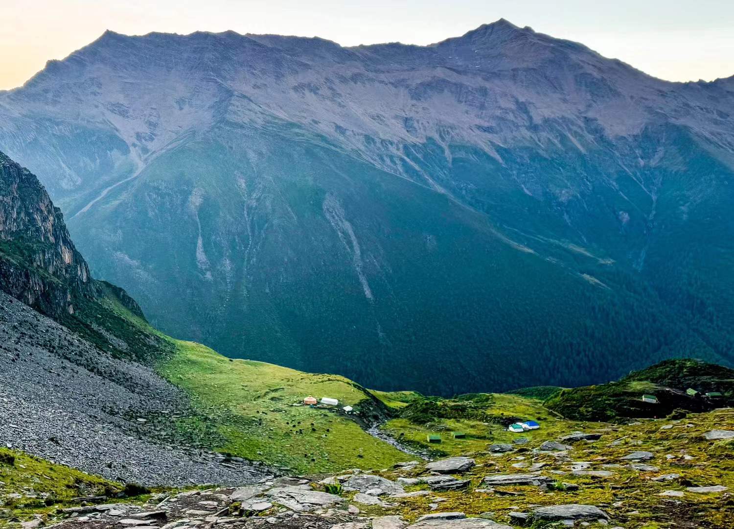 A green mountain valley held between steep ridges