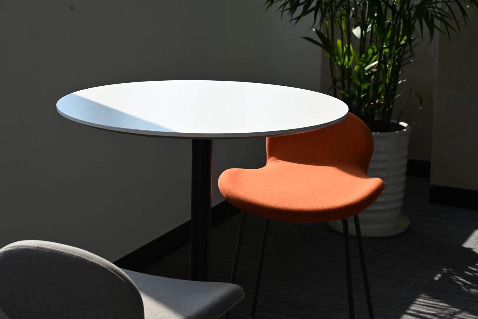 An orange chair and table cut by a rectangle of sunlight