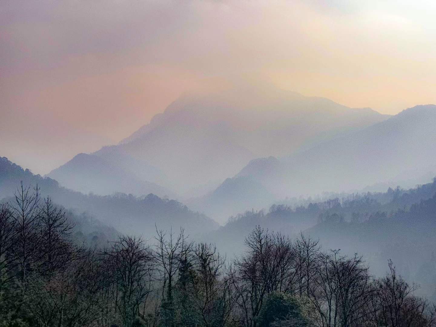 Layered mountains receding into silver mist
