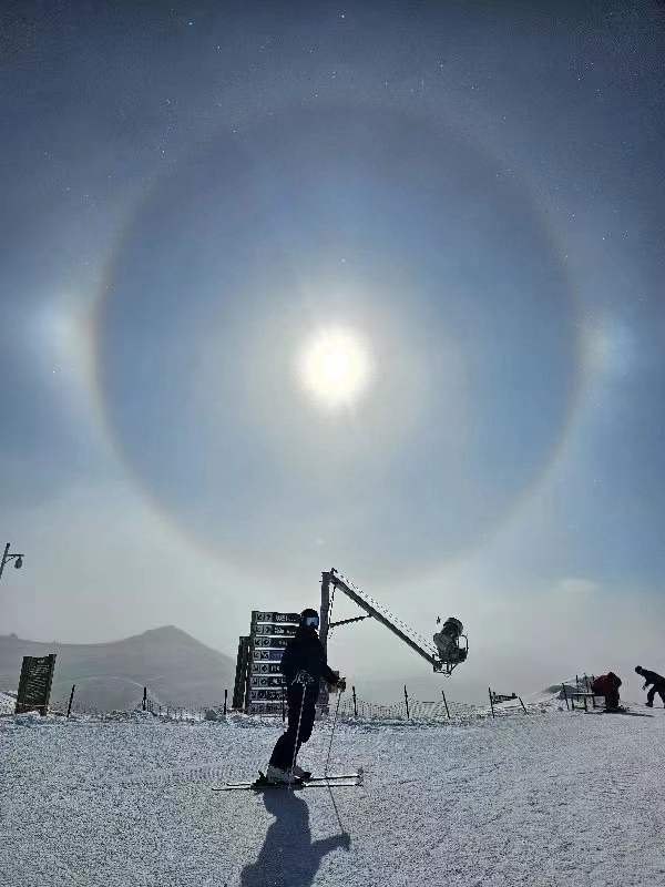 A solitary person beneath a winter halo