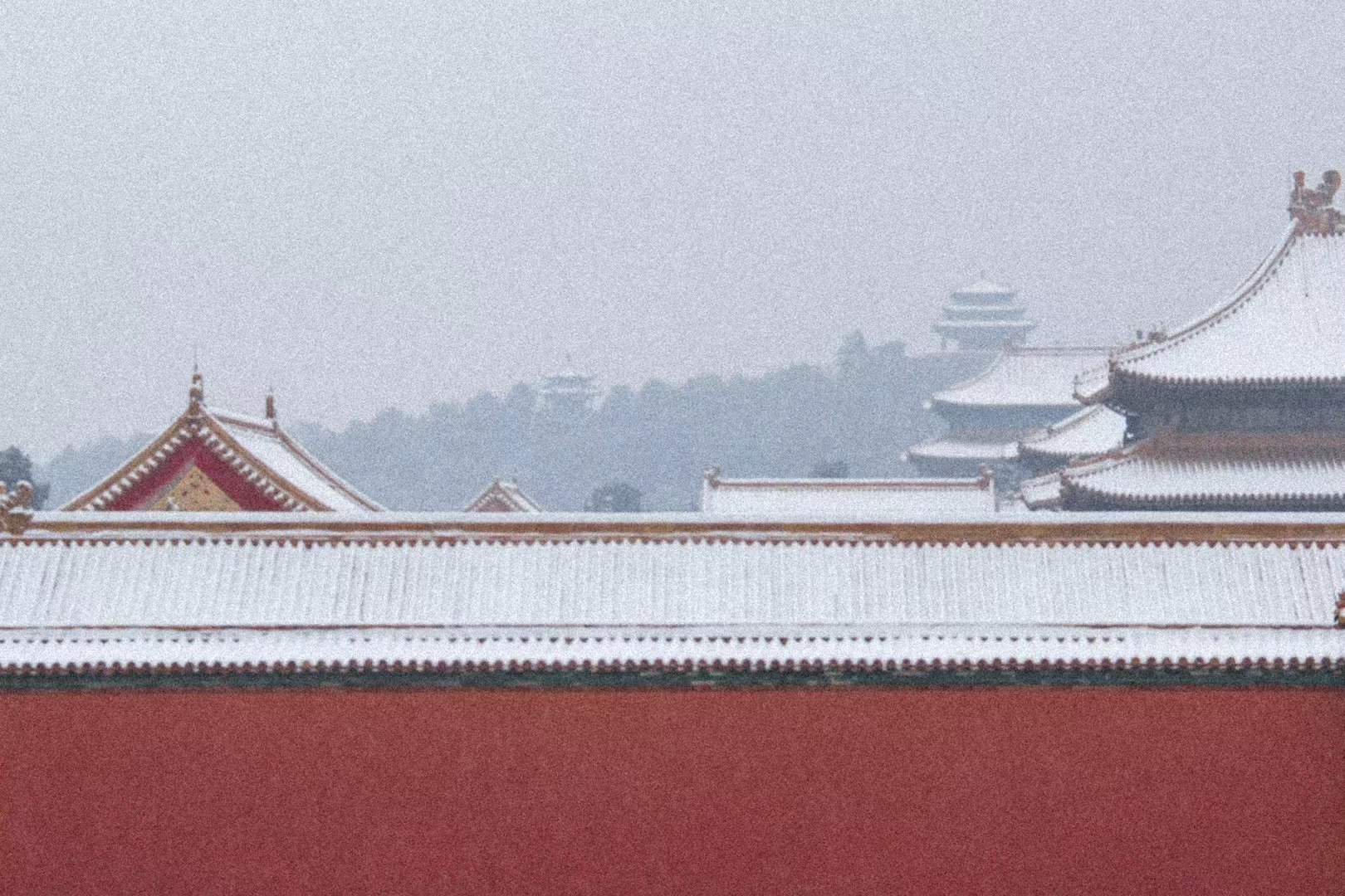 Red palace walls and white tiled roofs in snow