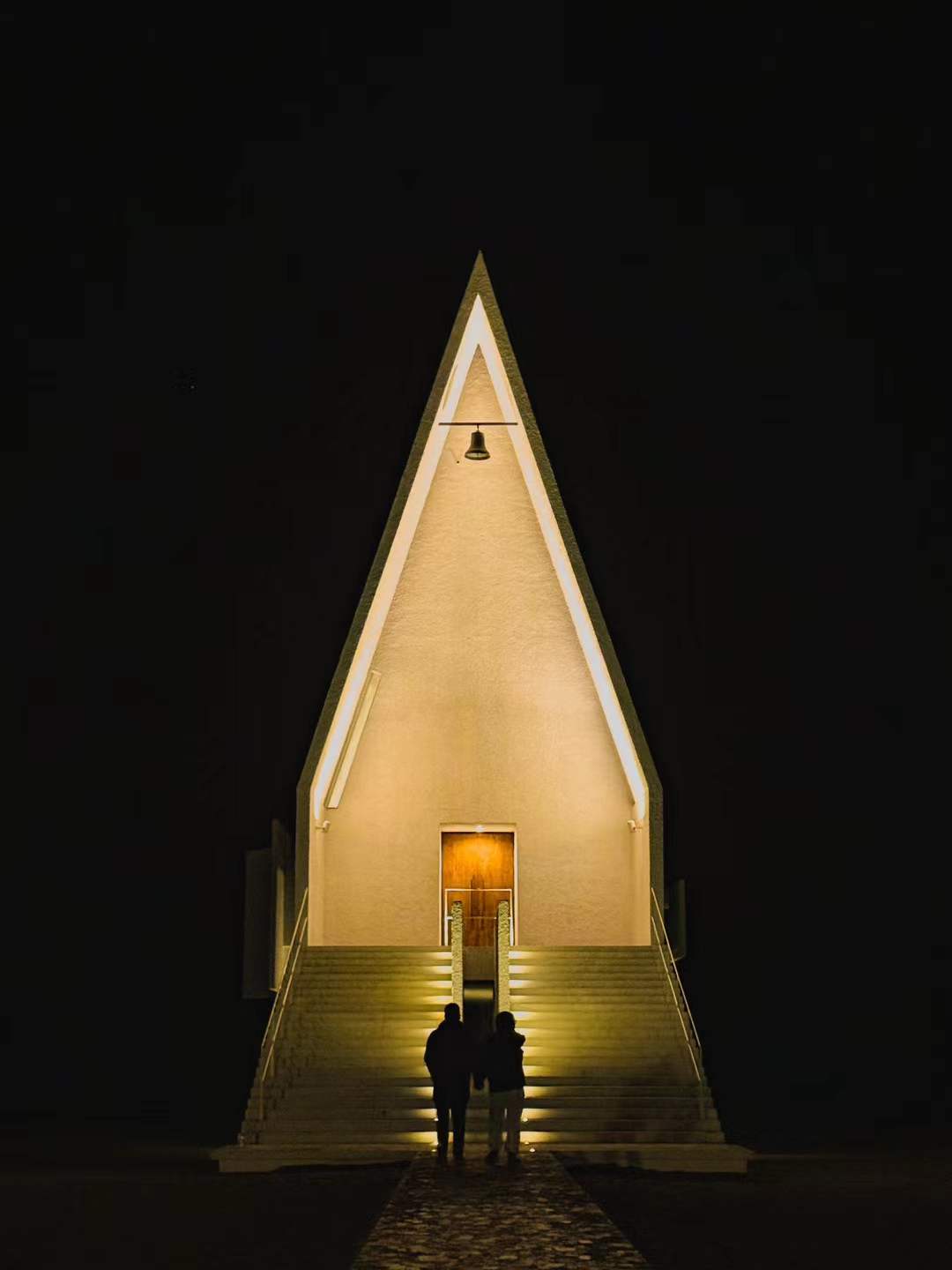 The same chapel at night with two figures below